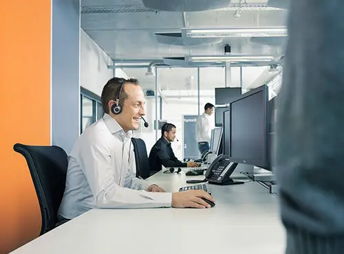 Un centre d’appels ou un bureau avec une isolation phonique, dans lequel un employé est au téléphone