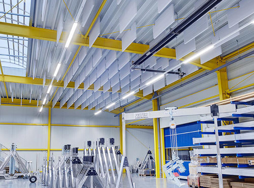 Plafond acoustique comme isolation acoustique dans un hall industriel. Les absorbeurs de bruit sont suspendus au plafond d’un hall industriel et réduisent le bruit.