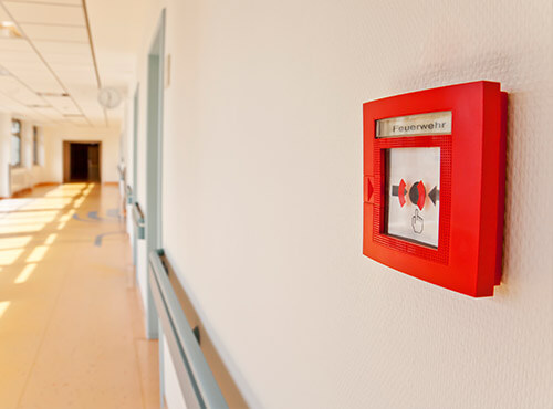 Protection incendie isolation phonique dans les écoles et les crèches Un détecteur d’incendie dans le couloir d’une école avec des dispositifs d’isolation phonique
