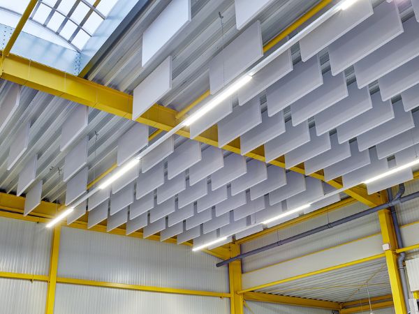 Absorbeur acoustique suspendu avec onestring dans un hall industriel